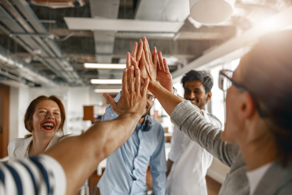 happy group of multi ethnic coworkers stacked hands together as concept of corporate unity